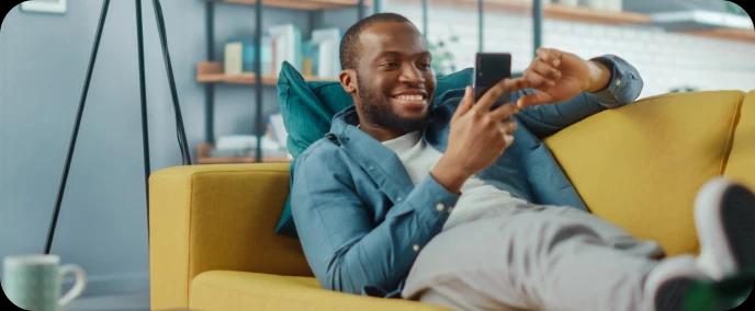 Homem feliz deitado no sofá